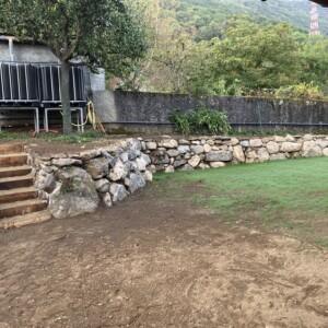 Terrassement, puis création d'un enrochement avec un accès escalier, puis engazonnement